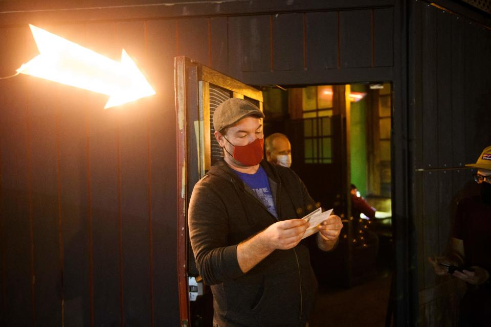 Kindrick Brooke checks a vaccination card outside Risky Business, that was once The Other Door but closed during the Covid-19 pandemic in the North Hollywood neighborhood of Los Angeles, California on May 21, 2021. (Patrick T. Fallon/AFP via Getty Images)