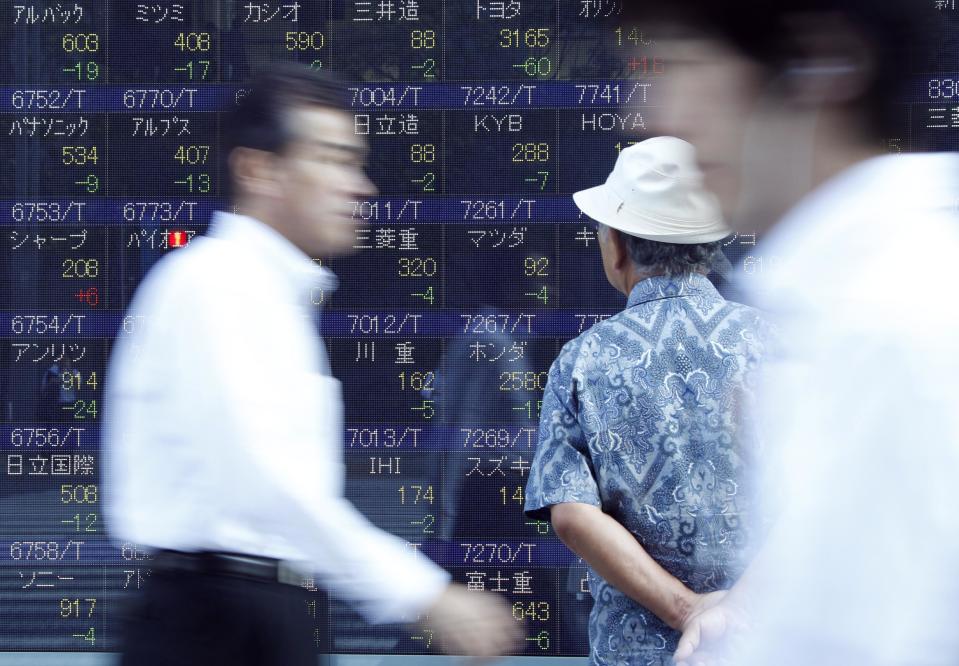 A man checks stock prices on the electronic stock board of a securities firm as others walk by in Tokyo Tuesday, Sept. 11, 2012. Asian stock markets retreated Tuesday as investors sought safety ahead of critical events this week that will test Europe's willingness to unite in order to deal with a major debt crisis. (AP Photo/Koji Sasahara)