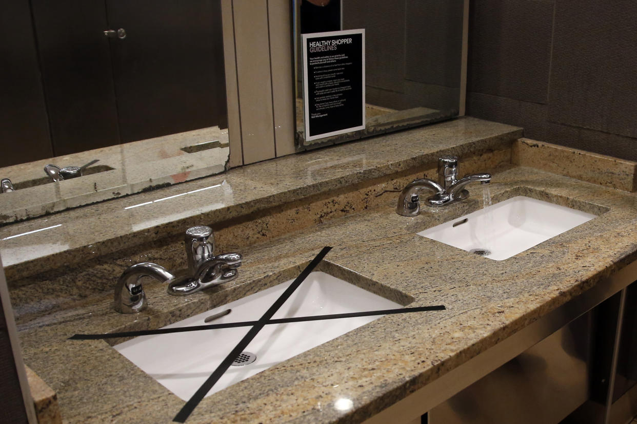 Alternating sinks in the restroom at Penn Square mall are taped off to promote social distancing as the mall reopens Friday, May 1, 2020, in Oklahoma City. The mall has closed one of two restrooms and five of seven entrances. The mall has been closed since mid-March due to coronavirus concerns. (AP Photo/Sue Ogrocki)