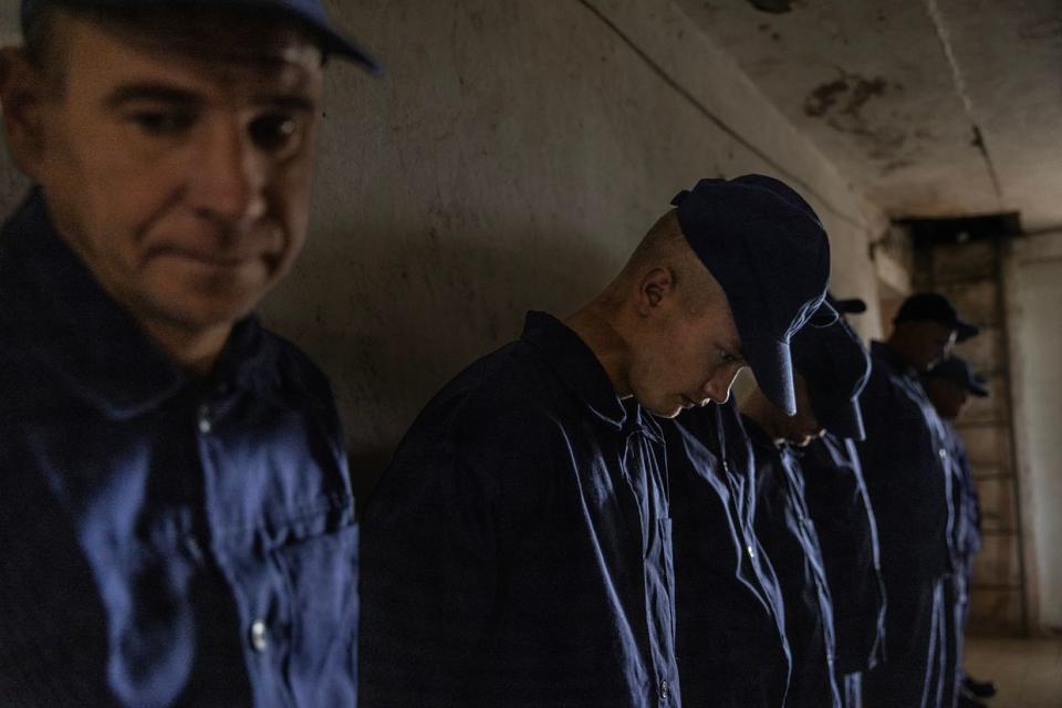 Russian POWs are seen waiting in line to call home to Russia in a prisoner-of-war detention camp on Aug. 3, 2023, in the Lviv region, Ukraine. Hundreds of captured Russian POWs including conscripts, mercenaries, Wagner militia, and Storm-Z Russian prisoners are being held in up to 50 sites around Ukraine. Storm-Z is a series of penal military units established by Russia since April 2023. (Paula Bronstein /Getty Images)