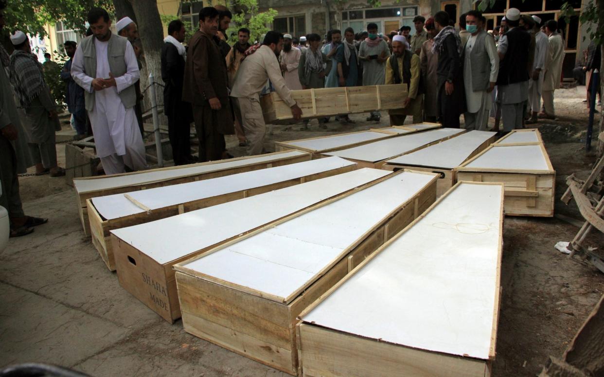 The coffins of the victims in Tuesday's attack are placed on the ground at a hospital in northern Baghlan province, Afghanistan, Wednesday, June 9, 2021. Workers of the HALO Trust de-mining organization were attacked on Tuesday night by the armed gunmen. (AP Photo/Mehrab Ibrahimi) - AP