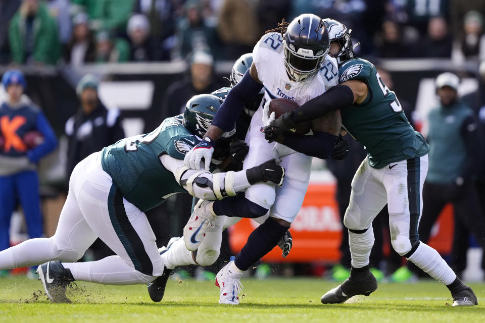 Tennessee Titans' Derrick Henry runs with the ball as players from the Philadelphia Eagles try to stop him during the first half of an NFL football game, Sunday, Dec. 4, 2022, in Philadelphia. (AP Photo/Matt Rourke)