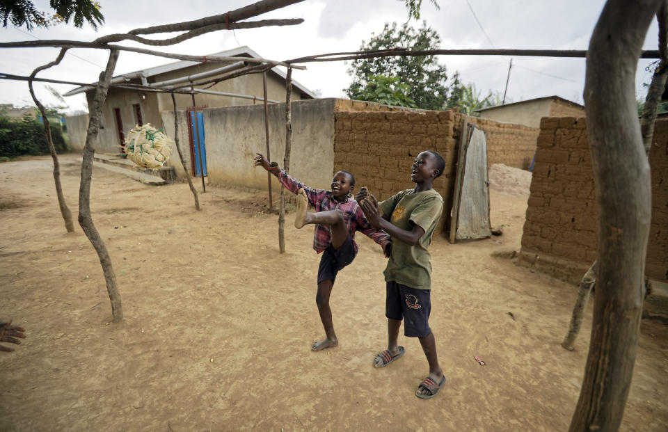 Children play with a ball made from plastic bags in the street outside their houses in the village of Mbyo, near Nyamata, in Rwanda Thursday, April 4, 2019. Rwanda will commemorate on Sunday, April 7, 2019 the 25th anniversary of when the country descended into an orgy of violence in which some 800,000 Tutsis and moderate Hutus were massacred by the majority Hutu population over a 100-day period in what was the worst genocide in recent history. (AP Photo/Ben Curtis)