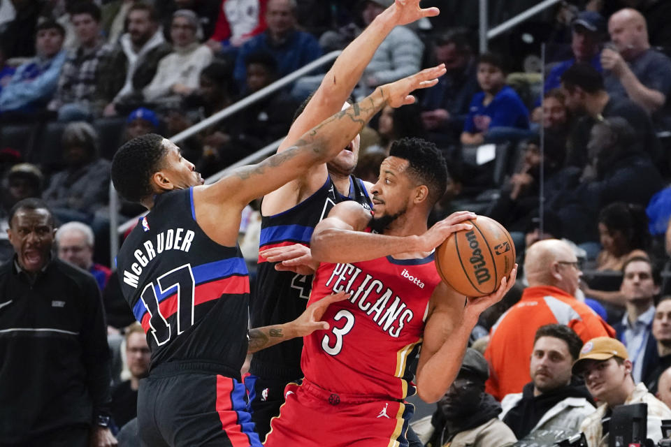 New Orleans Pelicans guard CJ McCollum (3) is pressured by Detroit Pistons guard Rodney McGruder (17) and Bojan Bogdanovic (44) in the first half of an NBA basketball game in Detroit, Friday, Jan. 13, 2023. (AP Photo/Paul Sancya)