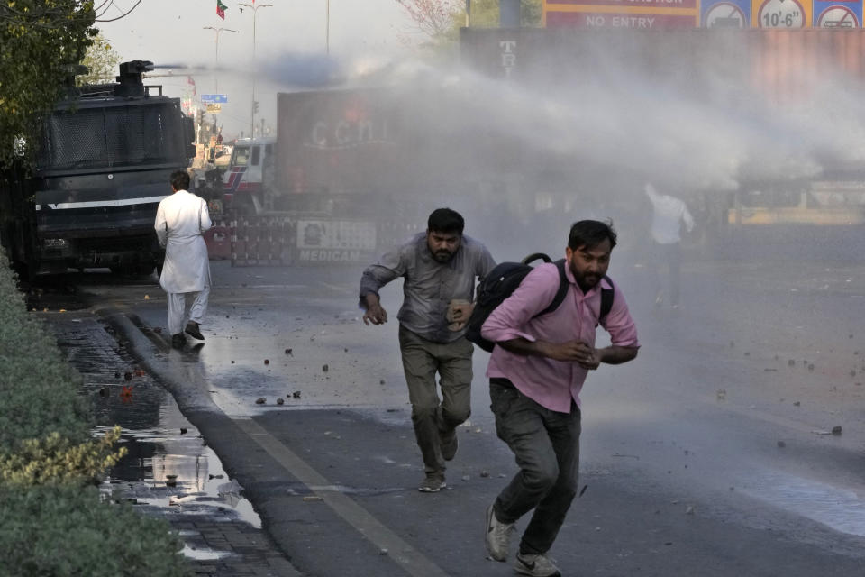 Police officers use water cannon to disperse the supporters of Pakistan's former Prime Minister Imran Khan during clashes, in Lahore, Pakistan, Wednesday, March 8, 2023. Pakistani police used water cannons and fired tear gas to disperse supporters of the country's former Prime Minister Khan Wednesday in the eastern city of Lahore. Two dozen Khan supporters were arrested for defying a government ban on holding rallies, police said. (AP Photo/K.M. Chaudary)