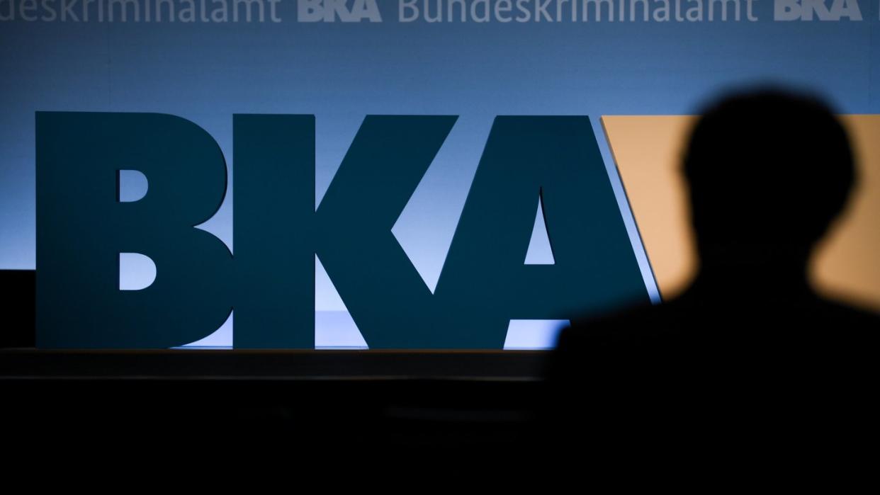 Auf einer Bundeskriminalamt-Tagung steht ein Mann vor dem BKA-Logo der Behörde.