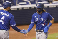 Toronto Blue Jays George Springer (4) congratulates Bo Bichette after Bichette scored during the sixth inning of a baseball game against the Miami Marlins, Tuesday, June 22, 2021, in Miami. (AP Photo/Marta Lavandier)