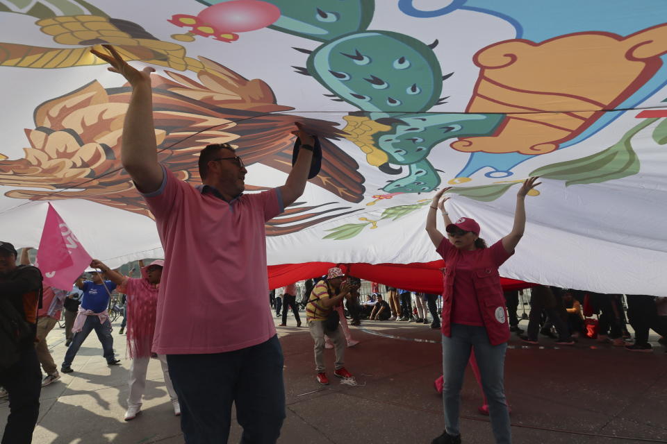 Partidarios de la oposición mexicana sostienen una bandera durante una manifestación, protestando por lo que afirman son intentos del presidente Andrés Manuel López Obrador de dividir al país, en el Zócalo de la Ciudad de México, el domingo 19 de mayo de 2024. México celebrará elecciones generales en junio 2. (Foto AP/Ginnette Riquelme)