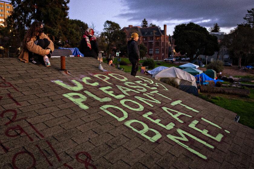 Berkeley, CA - January 03: People who live in People's Park along with activist keep watch on top of a building in Peoples's Park as UC Berkeley and other authorities prepare to cordon off People's Park on Wednesday, Jan. 3, 2024 in Berkeley, CA. (Jason Armond / Los Angeles Times)