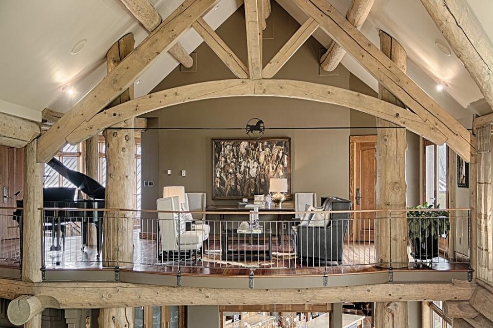 <p>Inside the main home, the 11,800-square-foot log building has lots of exposed beams and open, airy spaces, accented by limestone. (Listing via <a rel="nofollow noopener" href="http://sothebysrealty.ca/en/property/alberta/calgary-real-estate/calgary/63209/" target="_blank" data-ylk="slk:Sotheby’s Canada;elm:context_link;itc:0;sec:content-canvas" class="link ">Sotheby’s Canada</a>) </p>