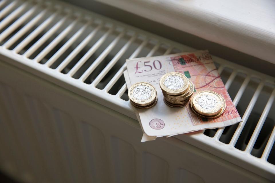 Housing costs Cost of living crisis. Money on a home radiator heater. Rising cost of energy and bills