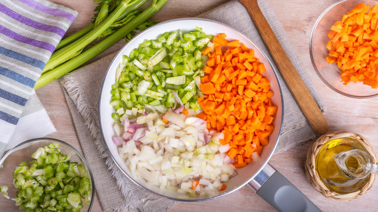 Mirepoix in pot on counter with vegetables