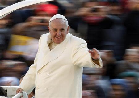 Pope Francis waves as he arrives to conduct his weekly general audience at St. Peter's Square at the Vatican December 11, 2013. REUTERS/Giampiero Sposito