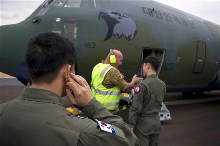 Republic of Korea Navy (ROKN) personnel talk with ground staff next to their C-130 Hercules aircraft after it arrived at the Royal Australian Air Force (RAAF) Base Pearce, located north of Perth, to participate in the search for missing Malaysia Airlines flight MH370 in the southern Indian Ocean in this picture released by the Australian Defence Force March 27, 2014. REUTERS/Australian Defence Force/Handout via Reuters