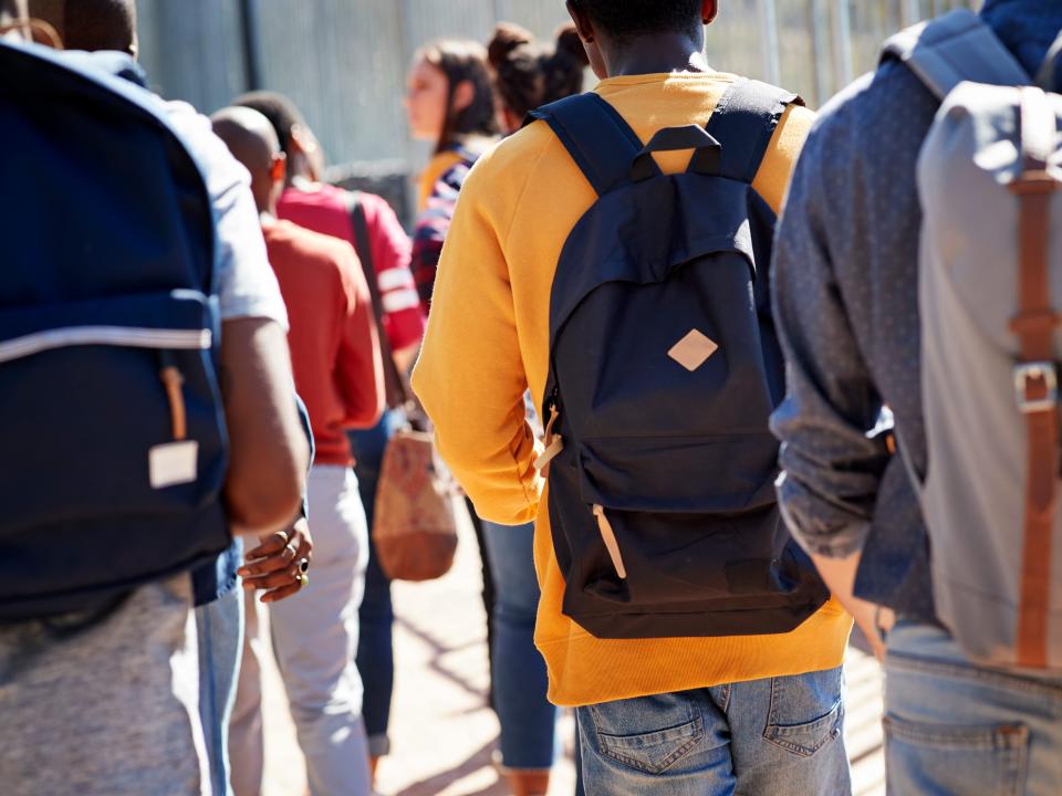 Male and female adult students walking at campus