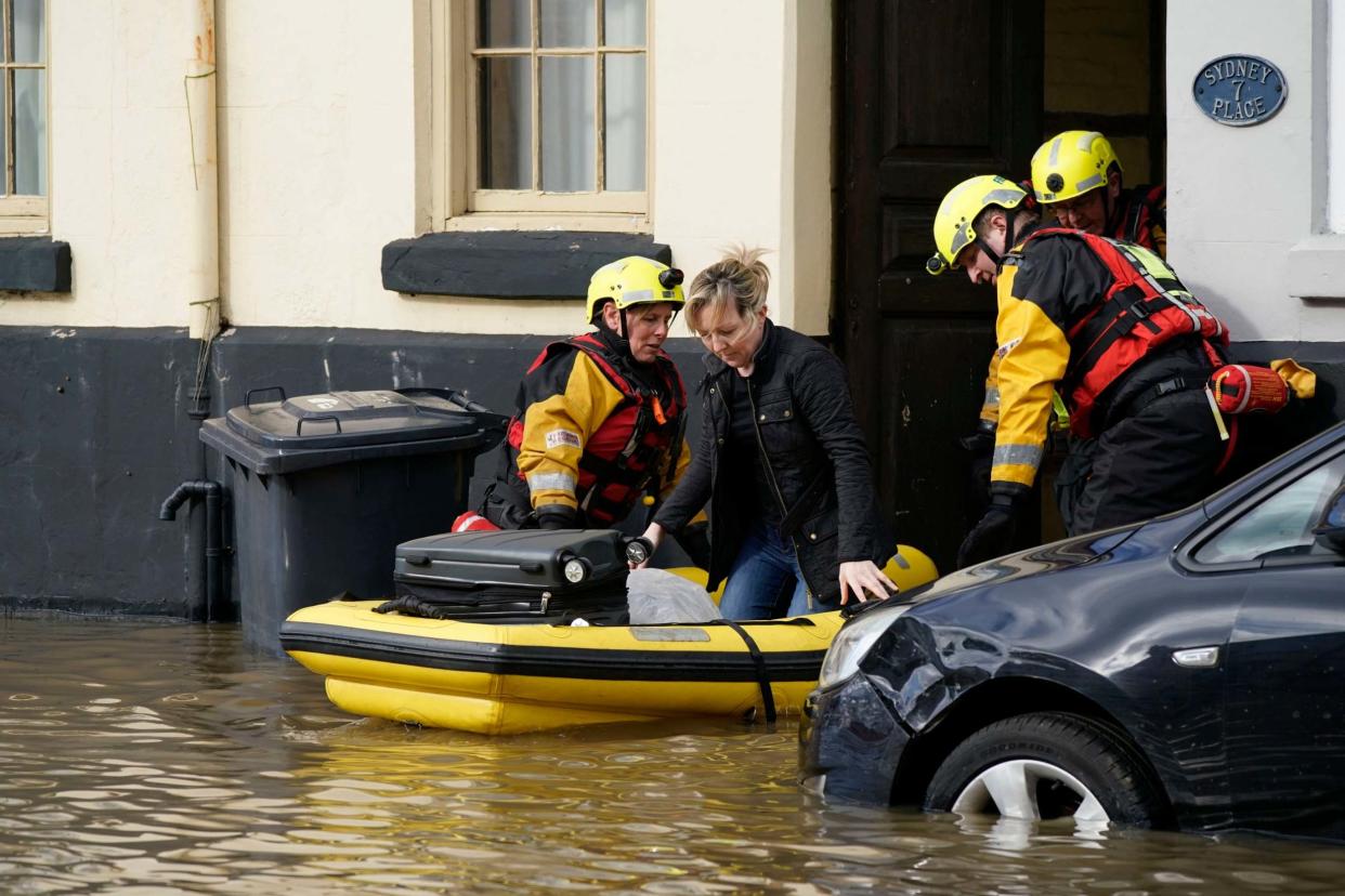 Rescue workers help a woman to safety in flood waters in Bewdley, where river levels could break a 20-year record as rain continues to fall: Getty Images