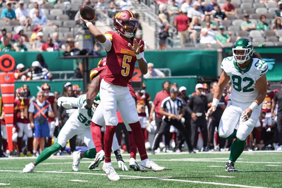 Aug 10, 2024; East Rutherford, New Jersey, USA; Washington Commanders quarterback Jayden Daniels (5) throws a pass during the first quarter against the New York Jets at MetLife Stadium. Mandatory Credit: Lucas Boland-USA TODAY Sports