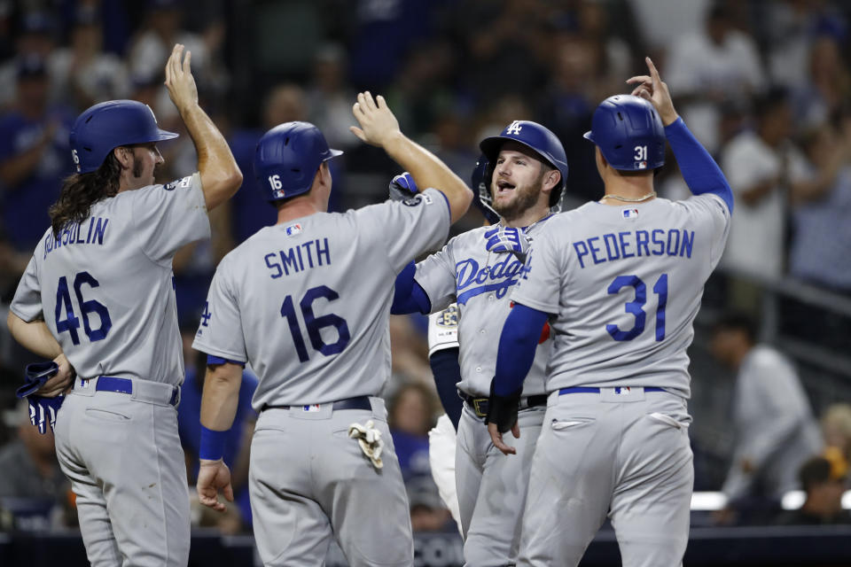 Los Angeles Dodgers' Max Muncy, second from right, greets teammates Tony Gonsolin (46), Will Smith (16), and Joc Pederson (31), after hitting a grand slam during the fourth inning of a baseball game against the San Diego Padres Tuesday, Sept. 24, 2019, in San Diego. (AP Photo/Gregory Bull)