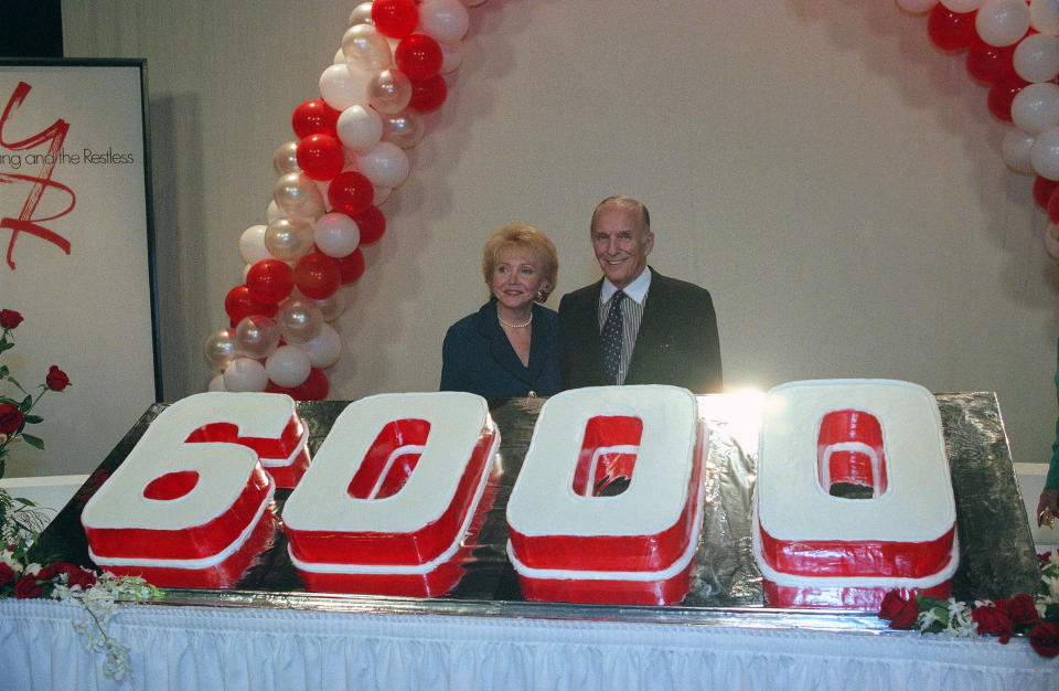 FILE - This Oct. 22, 1996 file photo shows co-creators of "The Young And The Restless," Lee Phillip Bell, left, and her husband William J. Bell Sr. standing by a celebratory cake marking the 6000th episode of the daytime soap opera series in Los Angeles. Lee Phillip Bell, who co-created “The Young and the Restless” and “The Bold and the Beautiful” and hosted her own daytime talk show in Chicago for 33 years, died Tuesday, Feb. 25, 2020 at her home in Los Angeles. She was 91. (AP Photo/John Hayes, File)