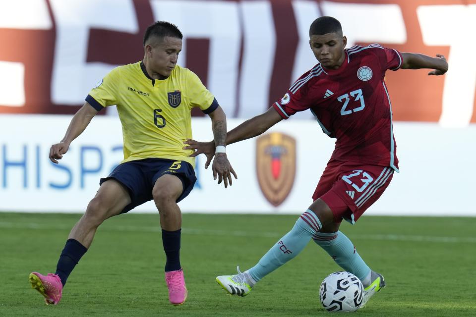 Layan Loor de Ecuador pelea por el balón con el colombiano José Escobar en el encuentro del preolímpico sudamericano sub-23 en el Estadio Brigido Iriarte en Caracas, Venezuela el sábado 20 de enero del 2024. (AP Foto/Ariana Cubillos)