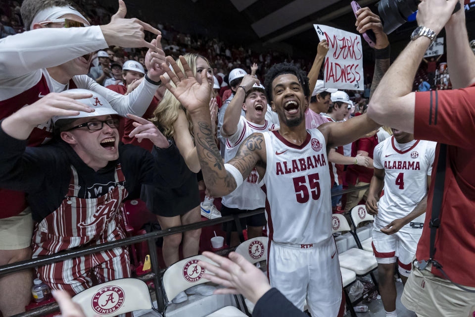 Alabama guard Aaron Estrada (55) celebrates with fans after the team's win over Florida in overtime in an NCAA college basketball game Wednesday, Feb. 21, 2024, in Tuscaloosa, Ala. (AP Photo/Vasha Hunt)