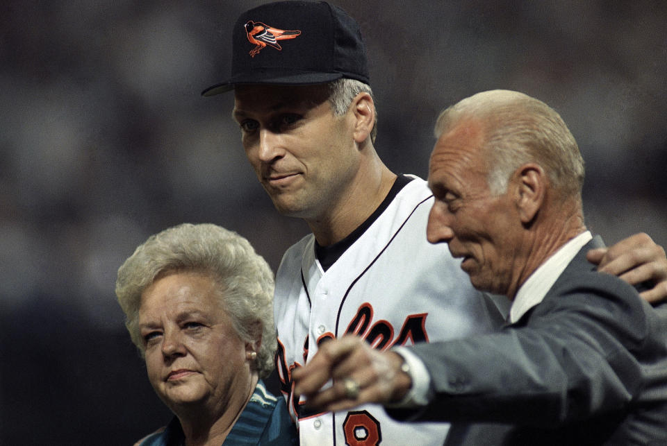 FILE - In this Sept. 6, 1995, file photo, Baltimore Orioles shortstop Cal Ripken, Jr., center, walk onto the field with his parents Violet, left, and Cal Ripken Sr. for postgame ceremonies in Baltimore. Cal Jr. broke Lou Gehrig's record of 2,130 consecutive games Sept. 6 as the Orioles defeated the California Angeles. Vi, matriarch of the famed Orioles family that includes Hall of Fame son Cal Jr. and once the victim of a bizarre kidnapping, has died. She was 82. Family spokesman John Maroon said she died Friday, Feb. 26, 2021, a day before her birthday. (AP Photo/Denis Paquin, File)