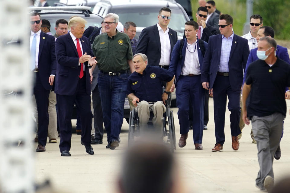 Former President Donald Trump, left, Texas Lt. Gov. Dan Patrick, center, and Texas Gov. Greg Abbott, right, visit an unfinished section of border wall, in Pharr, Texas, Wednesday, June 30, 2021. (AP Photo/Eric Gay)
