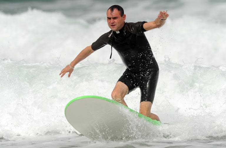 French Catholic priest Rene-Sebastien Fournie surfs at a beach in Bidart, southwestern France, on September 3, 2013