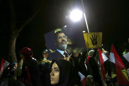 Pro-Islamists demonstrators holding a poster of deposed Egyptian President Mohamed Mursi, attend a protest against an Egyptian court's decision to sentence Mursi to death, in front of the Egyptian Consulate in Istanbul, Turkey, late June 16, 2015. REUTERS/Murad Sezer