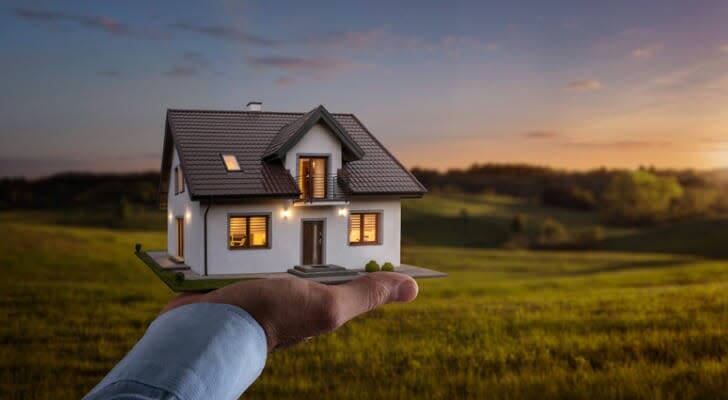 House being held in the palm of a man's hand