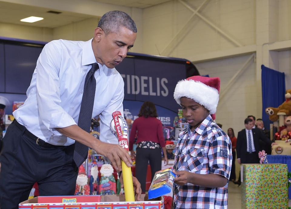 Obama and a young boy sort toys and gifts for the Marine Corps Toys for Tots campaign at Bolling Air Force Base in Washington, D.C., in December 2014. (Photo: MANDEL NGAN via Getty Images)
