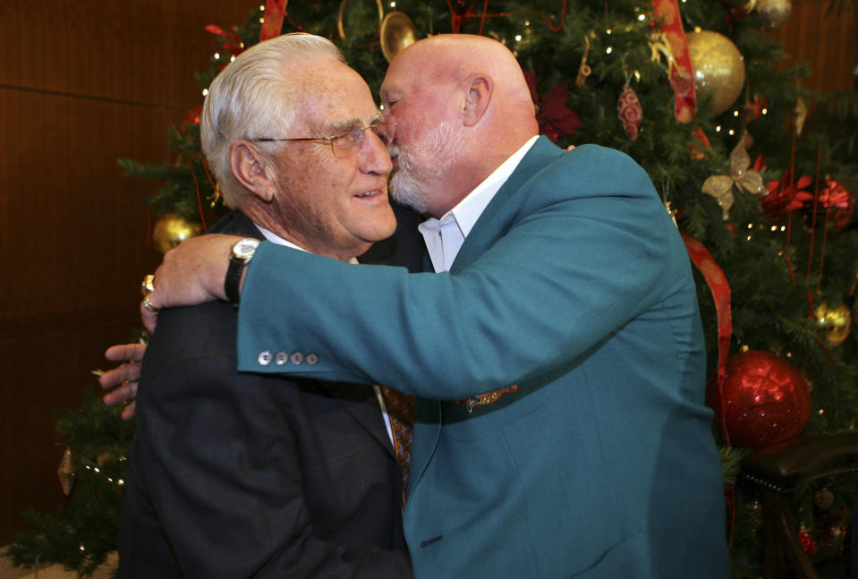FILE - In a Jan. 2, 2010 file photo, former Miami Dolphins head coach Don Shula, left, gets a hug and kiss from former NFL football player Bob Kuechenberg during Shula's 80th birthday party at the Land Shark Stadium in Miami. Former Miami Dolphins guard Kuechenberg, a six-time Pro Bowl selection and member of the only team to achieve a perfect season, died Saturday, Jan. 12, 2019. He was 71. His death Saturday was confirmed by the Dolphins, who had no further details. (AP Photo/Jeffrey M. Boan, File)