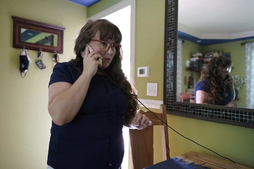 Allison Cullen, of Brockton, Mass.,speaks on the phone, Thursday, July, 22, 2021, with her husband Flavio Andrade Prado, a Brazilian national, from her home in Brockton. Prado is being held by Immigration and Customs Enforcement, or ICE, at the Plymouth County House of Corrections. Cullen, a mother of two, says she and her children haven't been able to visit her husband since before the pandemic. The number of detainees nationwide has more than doubled since the end of February, to nearly 27,000, according to recent data from U.S. Immigration and Customs Enforcement. (AP Photo/Steven Senne)