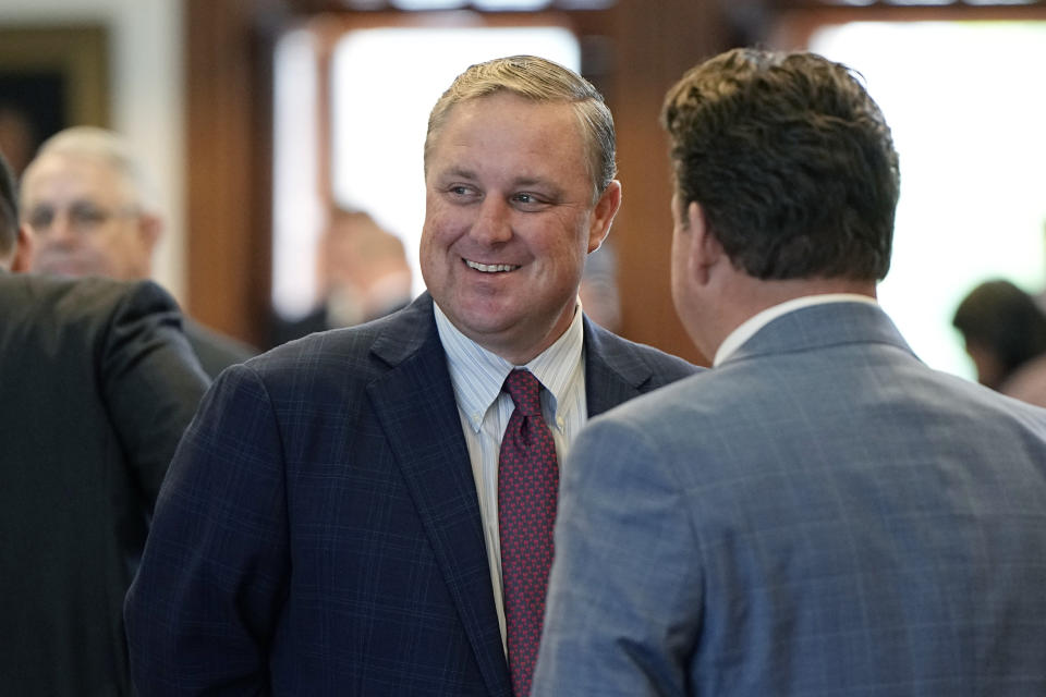 Texas state Rep. Justin Holland, R-Rockwall, left, talks with fellow members in the House chamber in Austin, Texas, Tuesday, May 9, 2023. (AP Photo/Eric Gay)