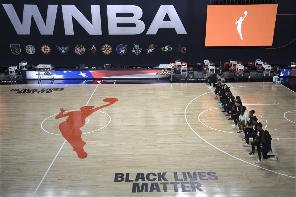 FILE - In this Aug. 30, 2020, file photo, members of the Connecticut Sun team kneel during the playing of the national anthem before a WNBA basketball game against the Washington Mystics, in Bradenton, Fla. Ahead of Labor Day, major U.S. labor unions say they are considering work stoppages in support of the Black Lives Matter movement. The unions say they're following the lead of professional athletes who last week staged strikes to protest the shooting of Jacob Blake in Kenosha, Wis. (AP Photo/Phelan M. Ebenhack, File)
