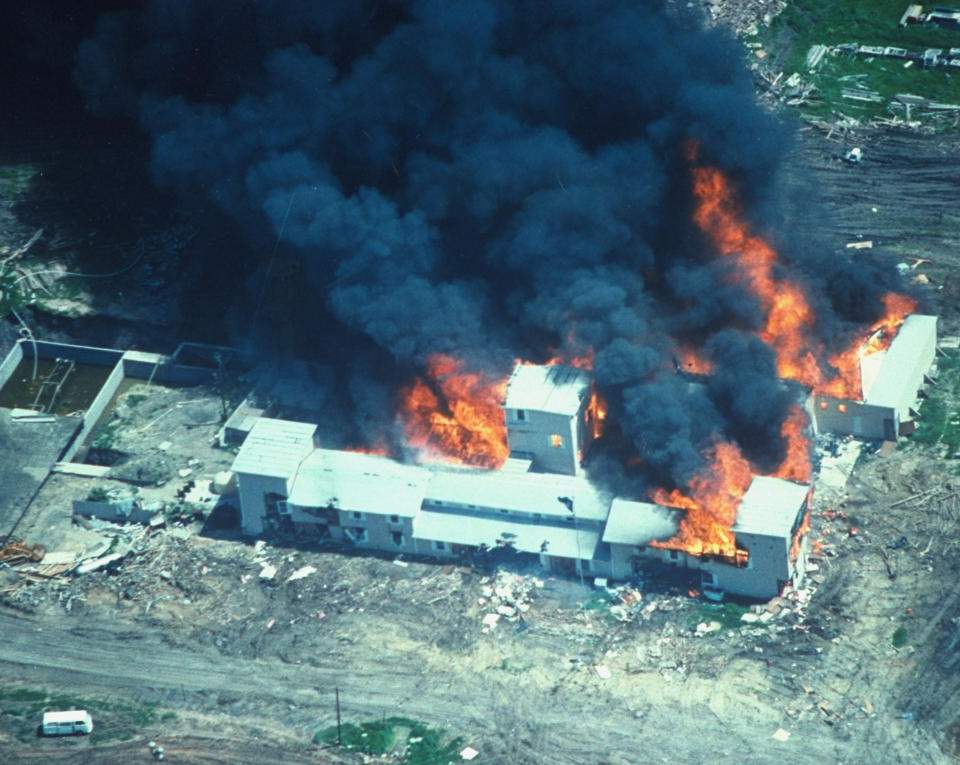 Overhead of smoking fire consuming David Koresh-led Branch Davidian cult compound