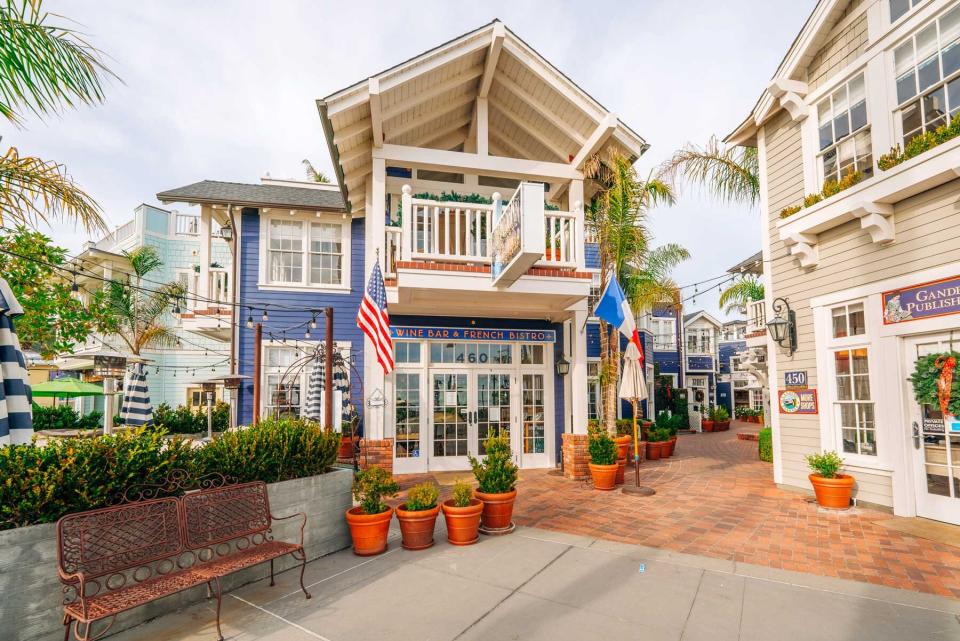 Avila Beach city promenade filled with restaurants, shops, patios, benches, and art.