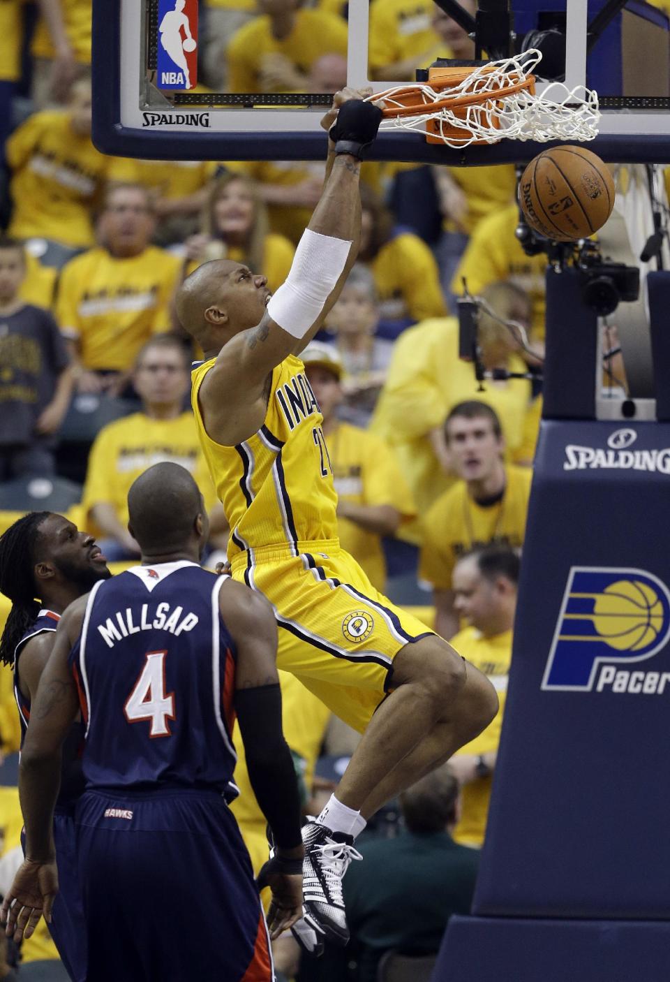 Indiana Pacers' David West (21) dunks against Atlanta Hawks' Paul Millsap (4) during the first half in Game 1 of an opening-round NBA basketball playoff series on Saturday, April 19, 2014, in Indianapolis. (AP Photo/Darron Cummings)