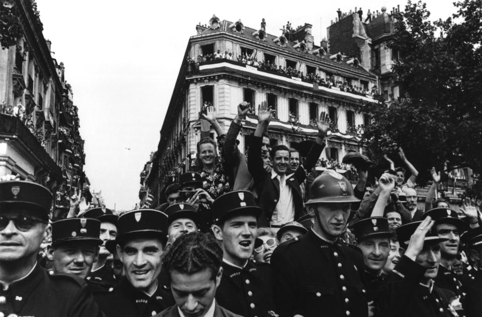 <p>Crowds fill up the Champs-Élysées on Aug. 26, 1944, to celebrate the liberation of Paris in France. “I would say that the war correspondent gets more drinks, more girls, better pay, and greater freedom than the soldier, but at this stage of the game, having the freedom to choose his spot and being allowed to be a coward and not be executed for it is his torture.” (© Robert Capa/International Center of Photography/Magnum Photos) </p>