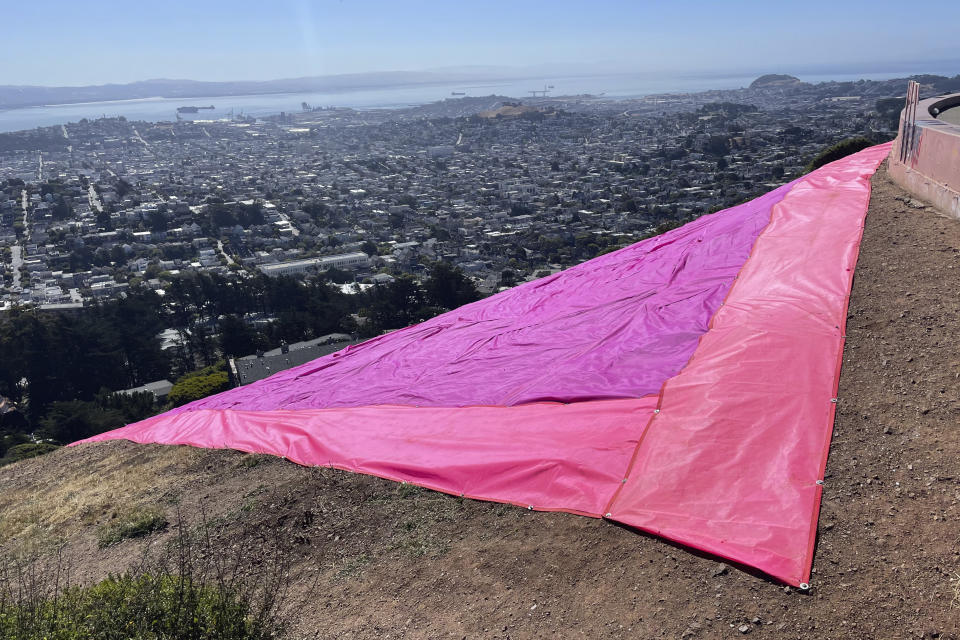 A section of the pink triangle is seen on Twin Peaks in San Francisco, Tuesday, June 20, 2023. Hundreds of volunteers installed the giant pink triangle made out of cloth and canvas and with pink lights around its edges last week as part of the city's Pride celebrations. It's an annual tradition that started in 1995 but this year's triangle is nearly an acre in size and can be seen up to 20 miles (32 kms.) away. (AP Photo/Haven Daley)