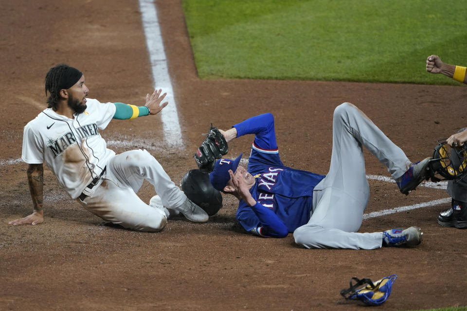 Seattle Mariners' J.P. Crawford, left, is out at home with a tag by Texas Rangers starting pitcher Kyle Gibson as Crawford tried to score on a single by Dylan Moore during the fifth inning of a baseball game Saturday, Sept. 5, 2020, in Seattle. (AP Photo/Ted S. Warren)