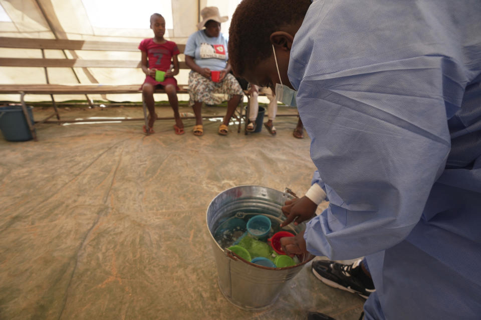 A nurse cleans cups inside a tent set aside for cholera patients at a clinic in Harare, Zimbabwe, Saturday Nov. 18, 2023.Zimbabwe is battling a cholera outbreak that has resulted in more than 150 suspected deaths countrywide. Health experts, authorities and residents blame the outbreak on acute water shortages and lack of access to sanitation and hygiene services (AP Photo/Tsvangirayi Mukwazhi)
