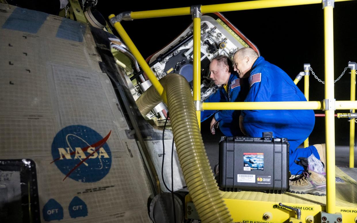 Nasa astronauts Mike Fincke (L) and Scott Tingle examine the spacecraft