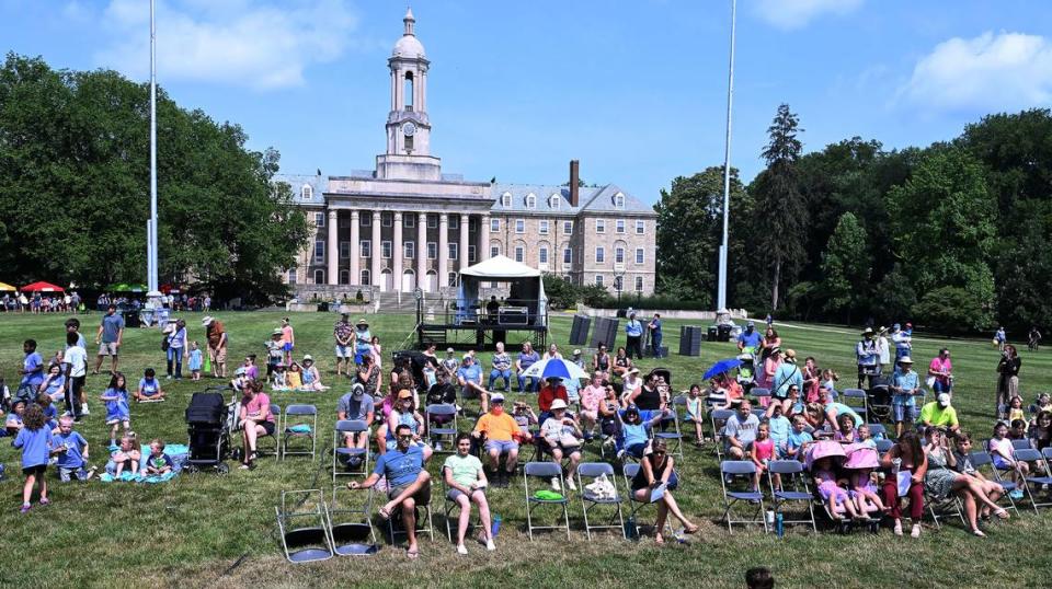 Visitors attending Wednesday’s Children and Youth Day at the 57th Central Pennsylvania Festival of the Arts in State College enjoy entertainment in front of Old Main.