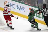 Carolina Hurricanes defenseman Jalen Chatfield (64) skates off as Dallas Stars left wing Roope Hintz (24) celebrates scoring a goal in the second period of an NHL hockey game Tuesday, Nov. 30, 2021, in Dallas. (AP Photo/Richard W. Rodriguez)