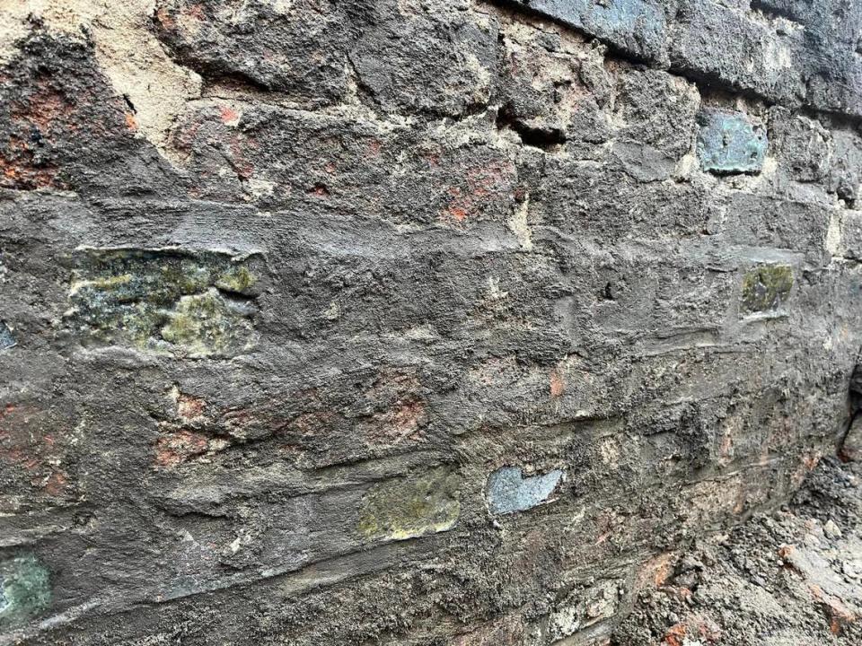 El muro de contención tenía manchas verdes, según los arqueólogos, quienes agregaron que estas manchas eran quizás reparaciones hechas en el muro.