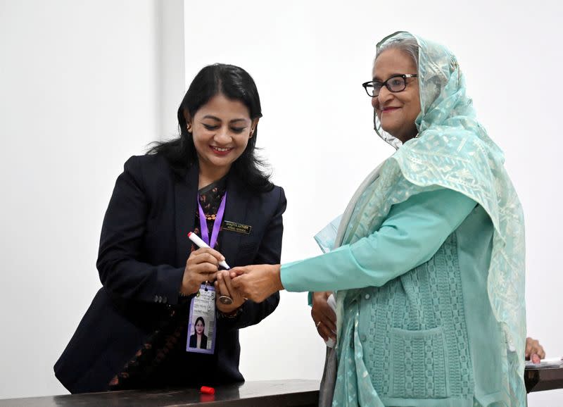 An officer puts an ink mark on the thumb of Sheikh Hasina, Prime Minister of Bangladesh during the 12th general election in Dhaka