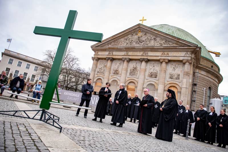 Worshippers carry a green cross across Bebel square in Berlin, during the Good Friday procession of St. Mary's Church. Fabian Sommer/dpa