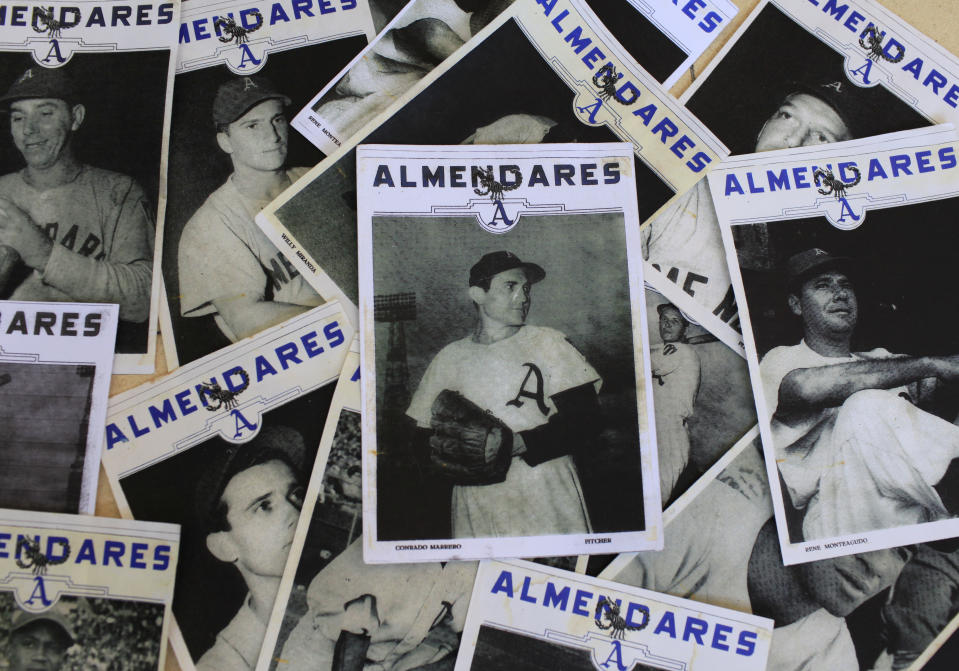 A photo of Conrado Marrero, center, sits on top of a collection of photos of his former teammates of the Cuban baseball team Almendares, at his home in Havana, Cuba, Thursday, April 25, 2013. Marrero, 102, the world's oldest living former major league baseball player, has much to celebrate this year. After a long wait, he finally received a $20,000 payout from Major League baseball granted to old-timers who played between 1947 and 1979. The money had been held up since 2011 due to issues surrounding the 51-year-old U.S. embargo on Cuba, which prohibits most bank transfers to the Communist-run island. But the payout finally arrived in two parts, one at the end of last year, and the second a few months ago, according to Marrero's family. (AP Photo/Franklin Reyes)