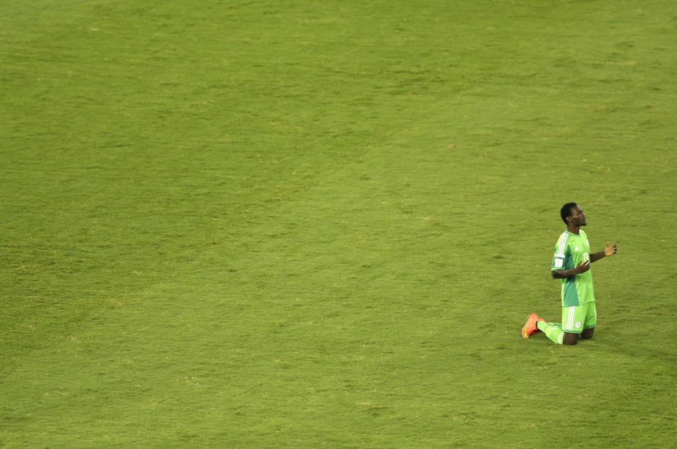 Nigeria's Juwon Oshaniwa prays prior to the group F World Cup soccer match between Nigeria and Bosnia at the Arena Pantanal in Cuiaba, Brazil, Saturday, June 21, 2014. (AP Photo/Fernando Llano)